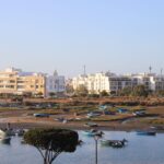 Scenic view of fishing boats moored near modern apartments in Rabat, Morocco.