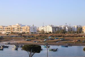 Scenic view of fishing boats moored near modern apartments in Rabat, Morocco.
