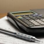 a calculator and a pen sitting on top of a piece of paper